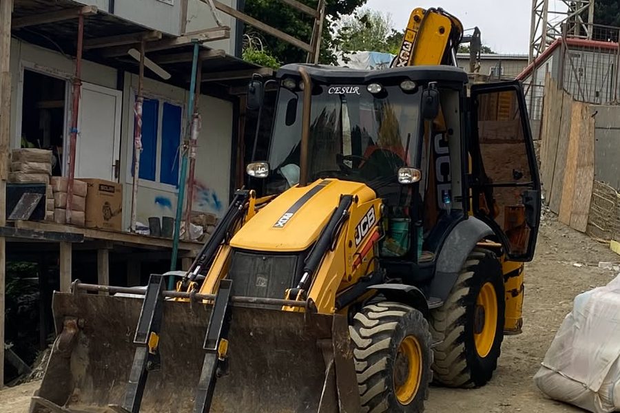 Şantiye ofisinin önünde çatal ataşmanlı JCB beko loder